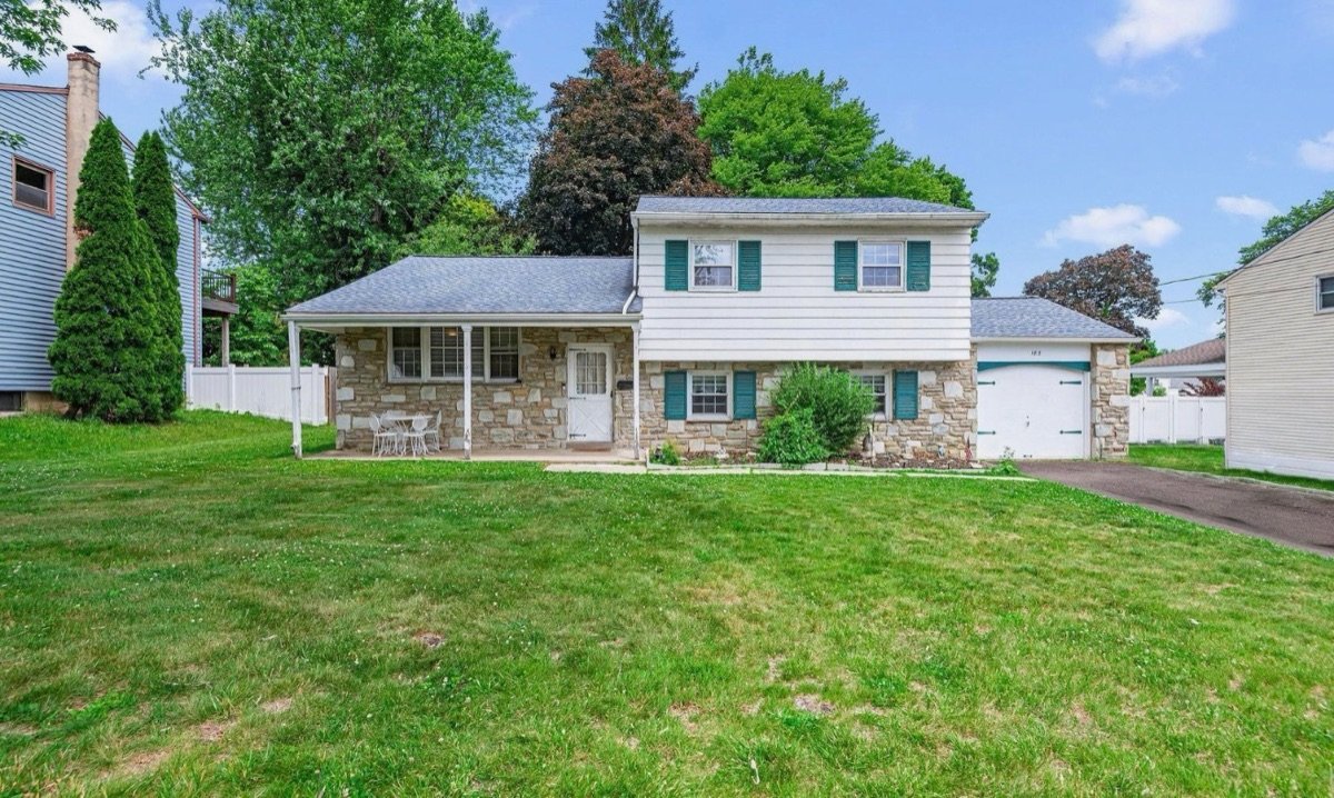 Before exterior renovation — home with blue-gray roof and dated siding