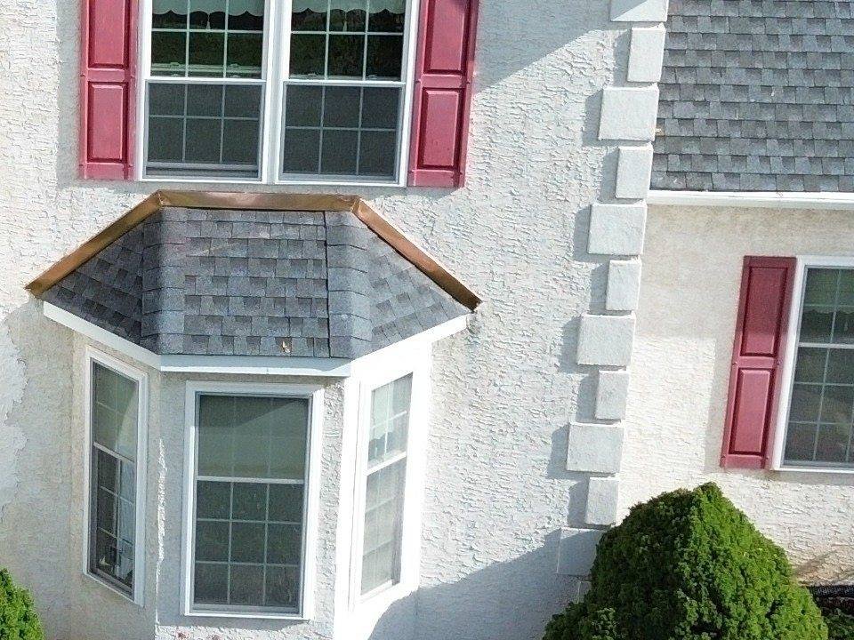 Copper flashing on a bay window roof where it meets a stucco wall, completed by Shelby Roofing Services in Plymouth Meeting, PA