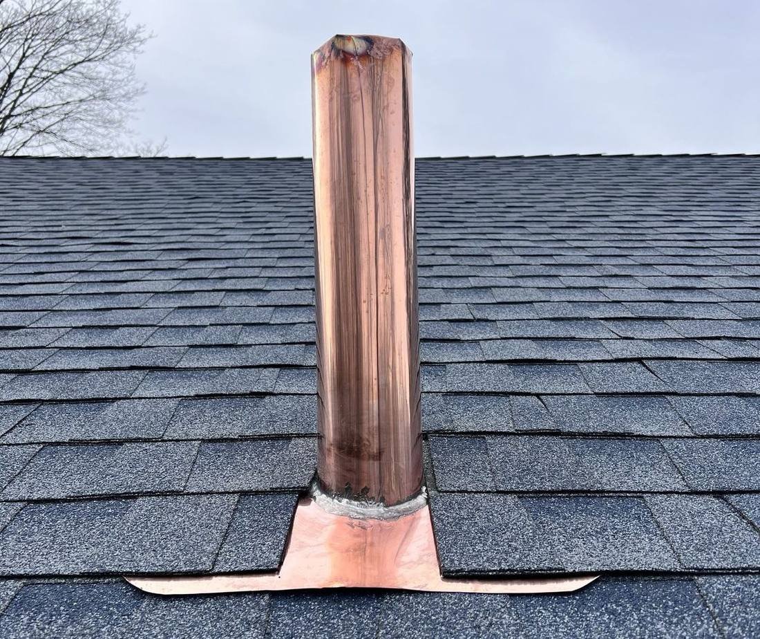 Close-up of a copper pipe boot flashing on a new shingle roof installed by Shelby Roofing Services