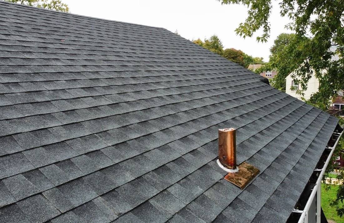 Copper pipe boot flashing on a new charcoal shingle roof by Shelby Roofing Services