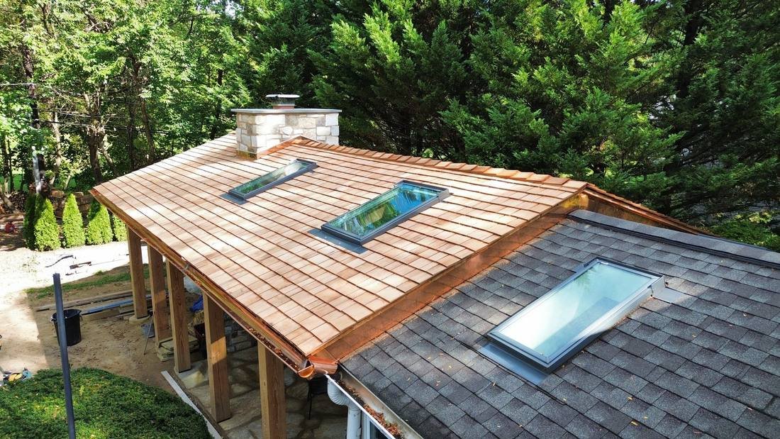 Skylights on a cedar shake porch roof and an asphalt shingle sunroom roof during a Shelby Roofing Services project in Bryn Athyn, PA