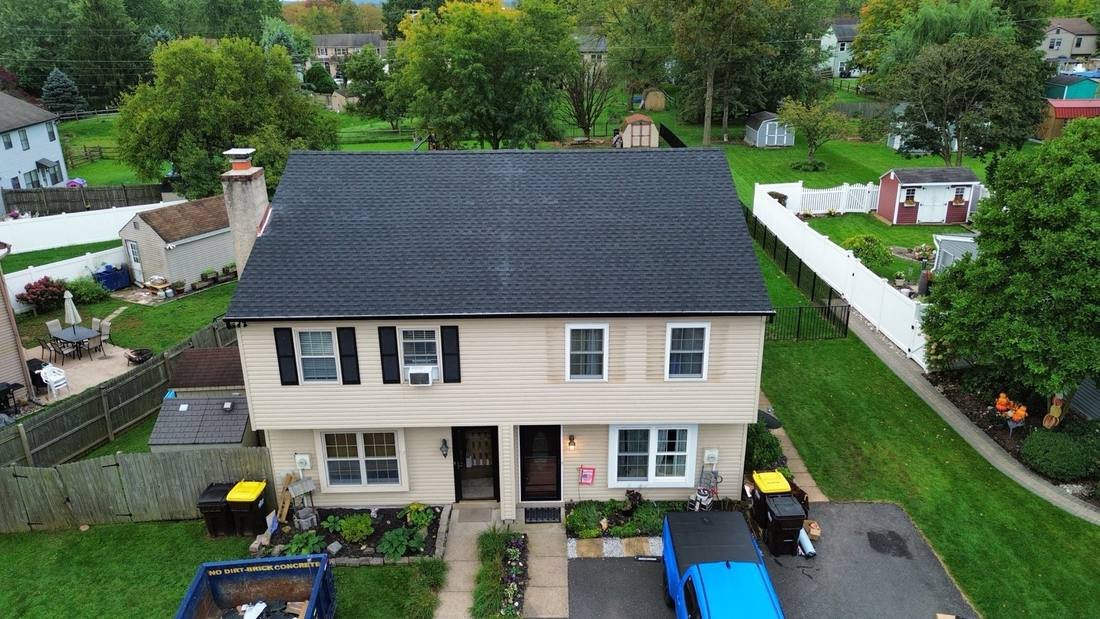 Aerial view of a home with a new black shingle roof, fascia and gutters completed by Shelby Roofing Services