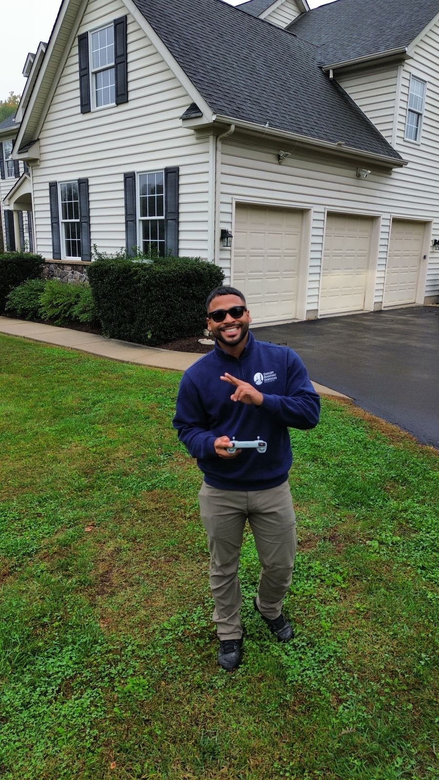 Miguel Cespedes with a drone controller in front of the home before the exterior restoration begins