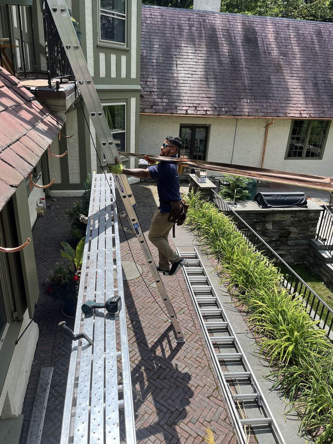 Miguel Cespedes personally installing copper gutters and downspouts — hands-on craftsmanship