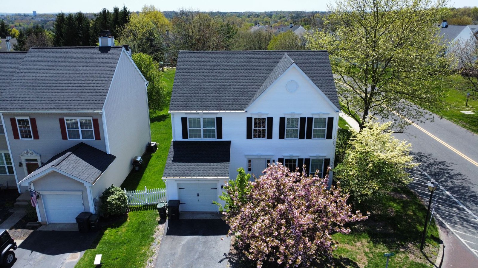 After — completed home with new charcoal shingles, white siding, and black shutters — Shelby Roofing Services PA