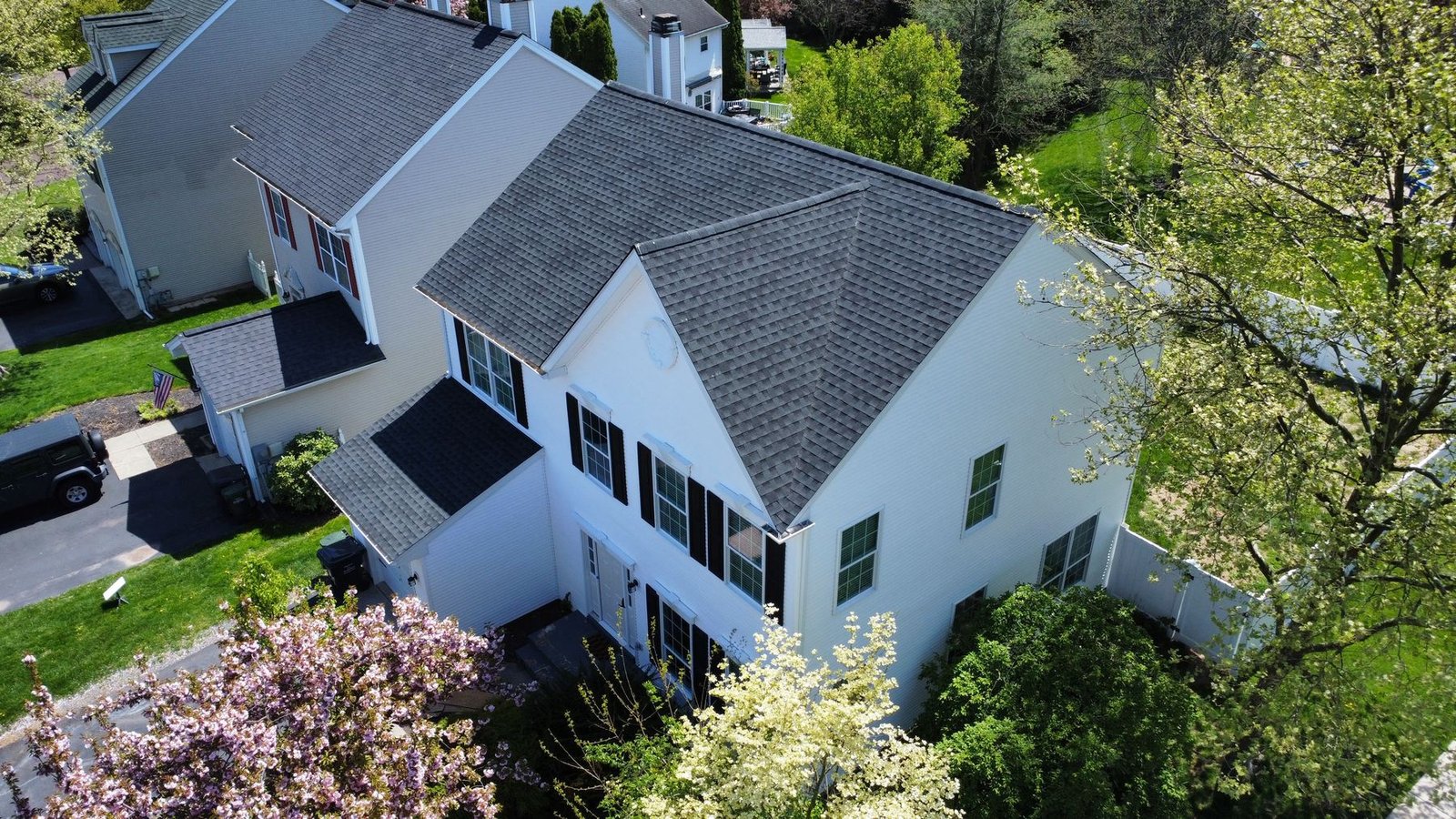 After — front-left aerial of completed home renovation with cherry blossom tree — Shelby Roofing Services PA