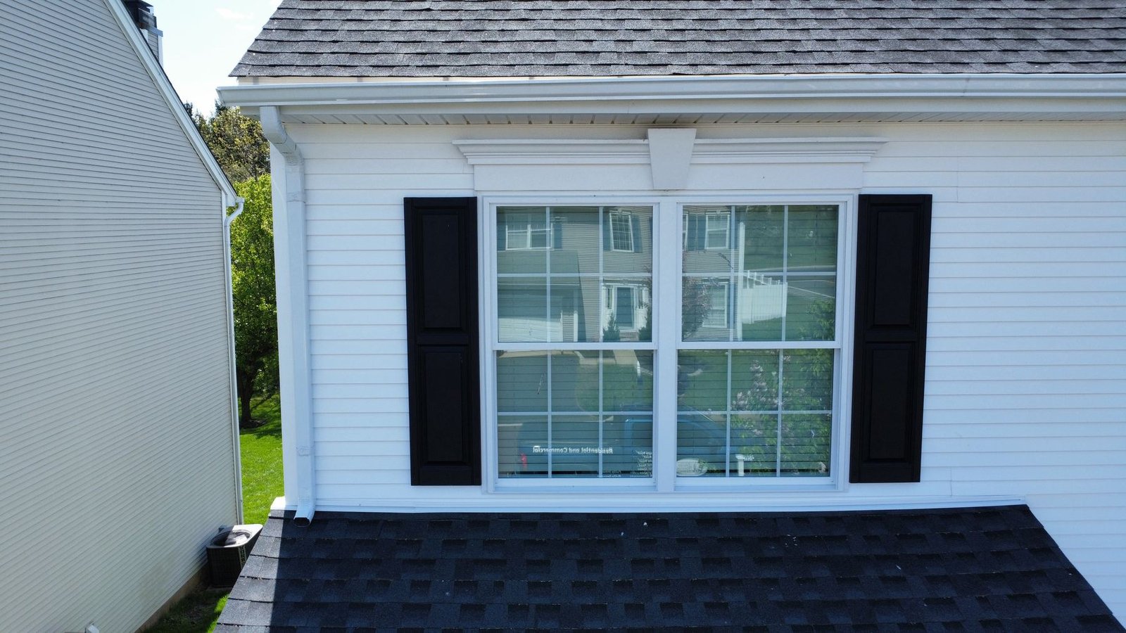 After — new Harvey windows with black shutters and white siding completed — Shelby Roofing Services PA