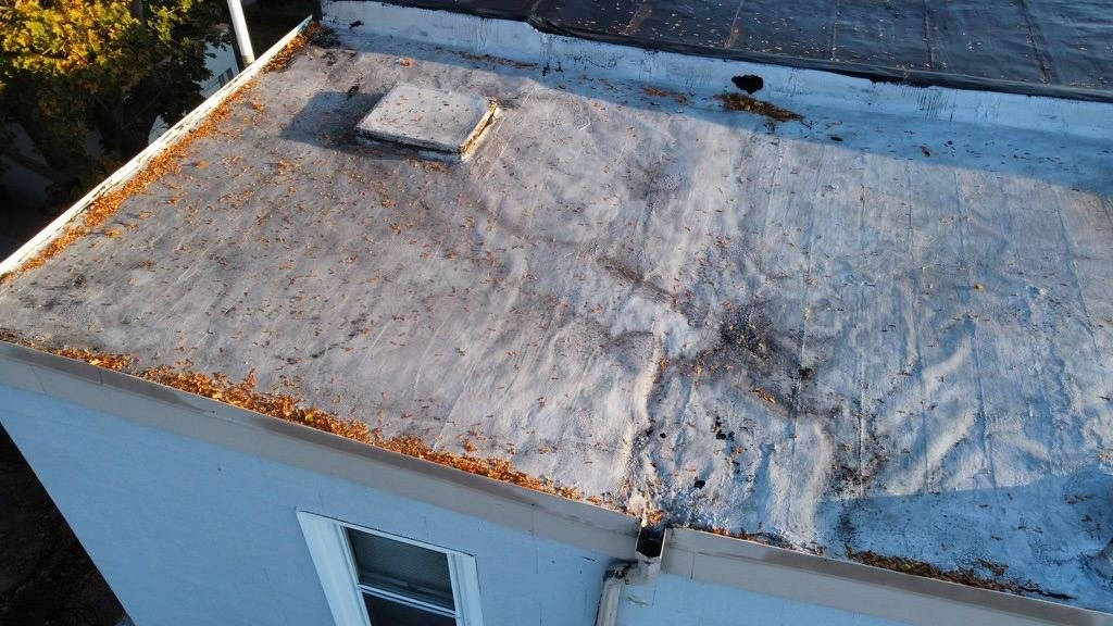 Before — close-up of severely deteriorated flat roof membrane with cracks and debris, PA