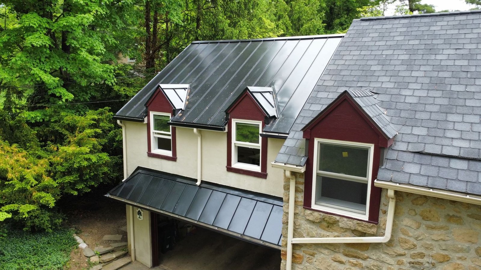 After — front view of two dormers with new standing seam metal and garage below — Shelby Roofing Services PA