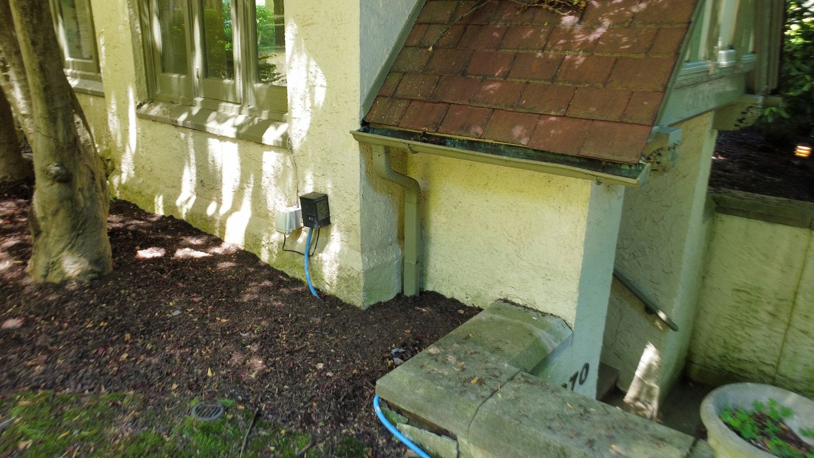 Before — corner of Tudor estate showing old deteriorating downspout and gutter, PA
