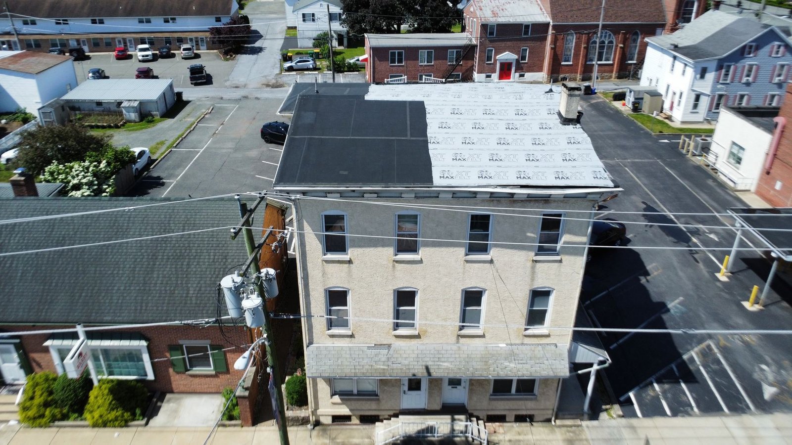 Before — aerial of secondary commercial building showing failed flat roof requiring full replacement, PA