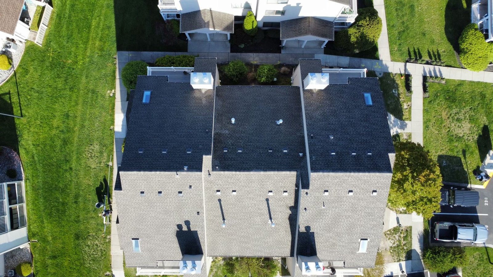 After — top-down aerial of completed condo complex with new charcoal shingles — Shelby Roofing Services PA