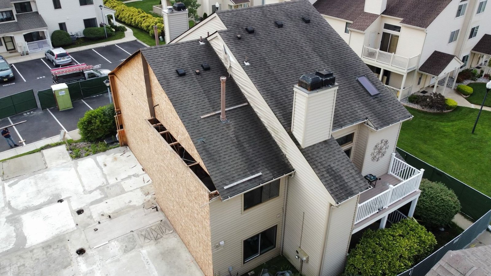 Before — aerial of condo building with storm damage and siding blown off gable, PA