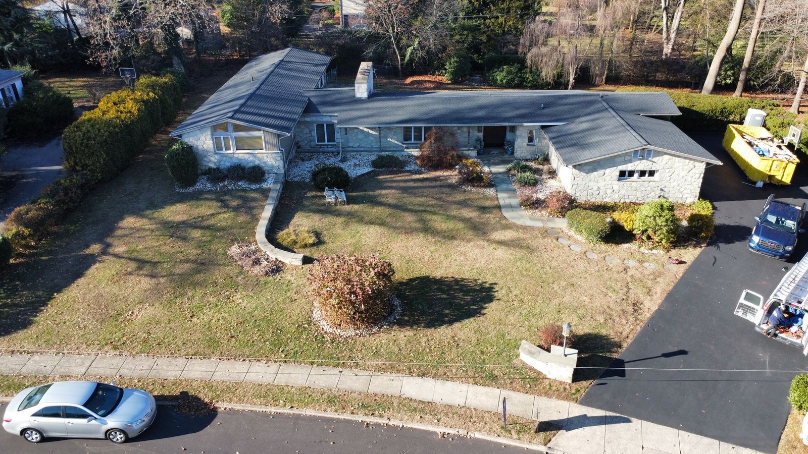 After — front aerial of completed stone ranch with new dark charcoal shingles — Shelby Roofing Services PA