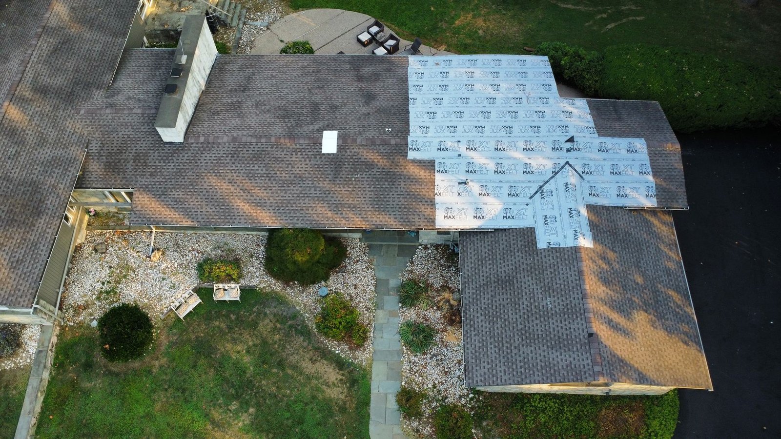 Before — top-down aerial of stone ranch with emergency tarp, PA