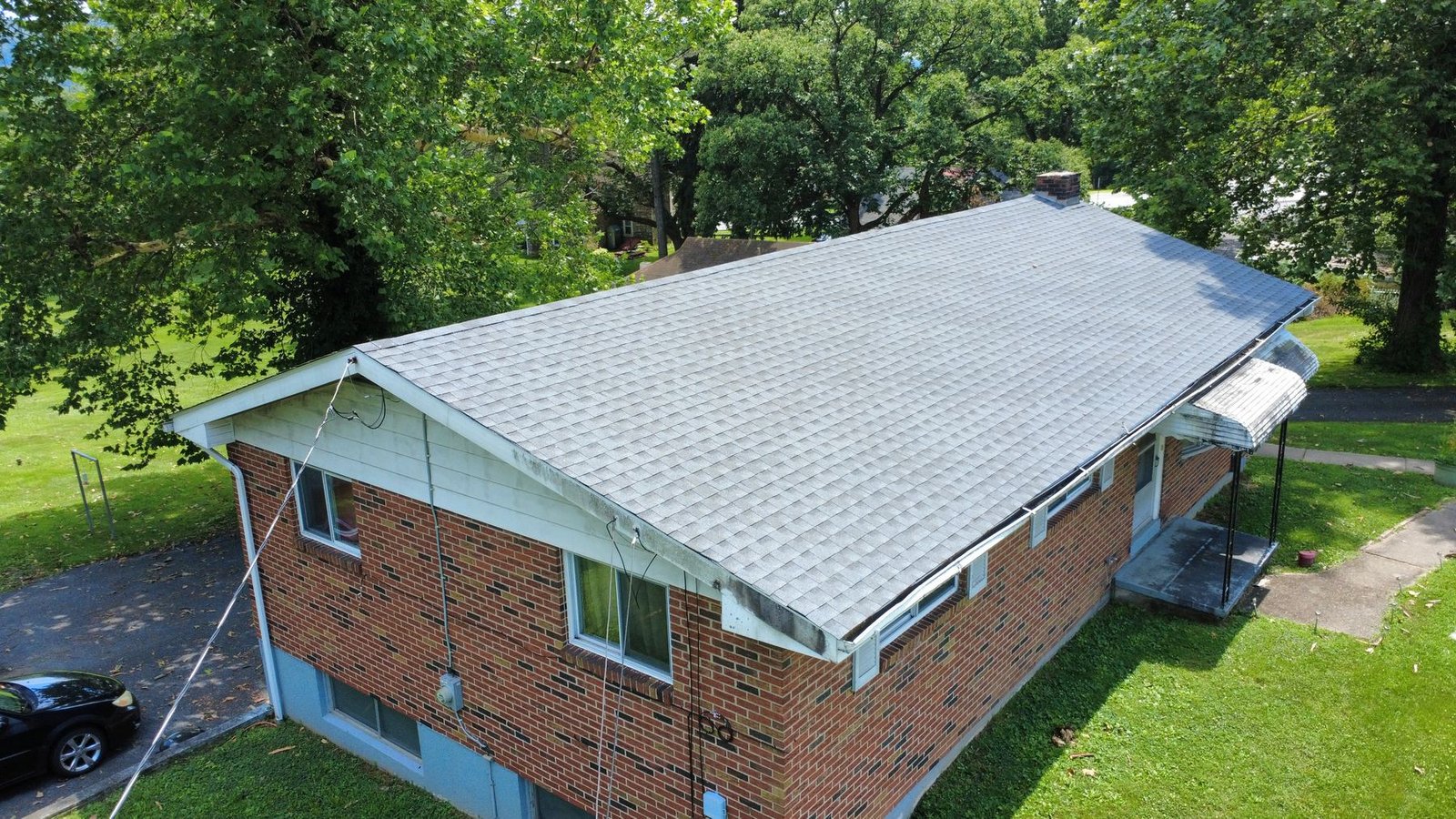 After — front aerial of brick ranch with new light gray shingles — Shelby Roofing Services PA
