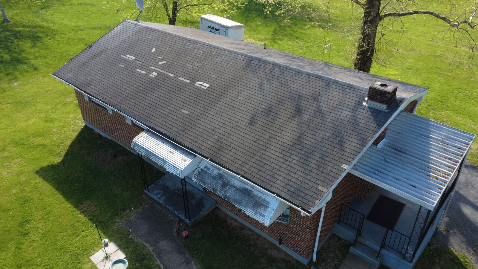 Before — side aerial of brick ranch showing shingle deterioration, PA