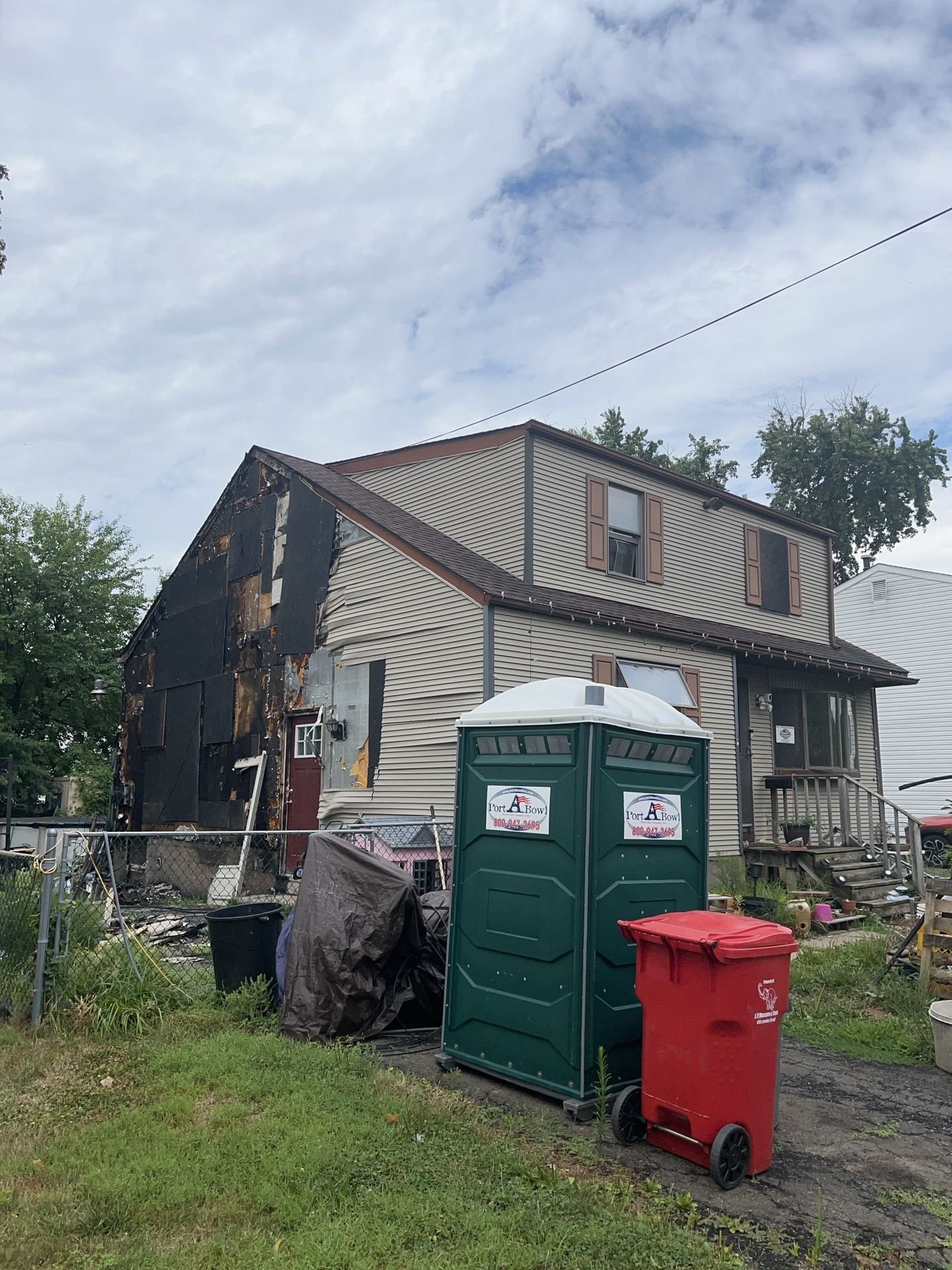 Before — side of gambrel cape with original beige siding and old shingles, NJ