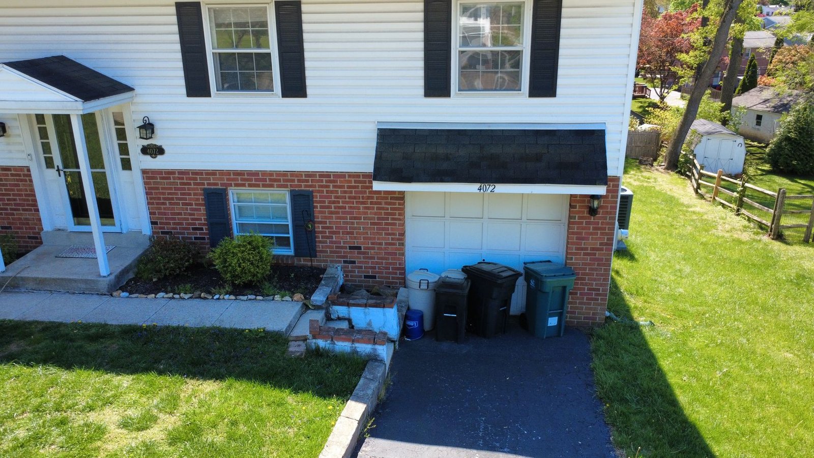 Before — front of split-level brick home with old shingles, PA