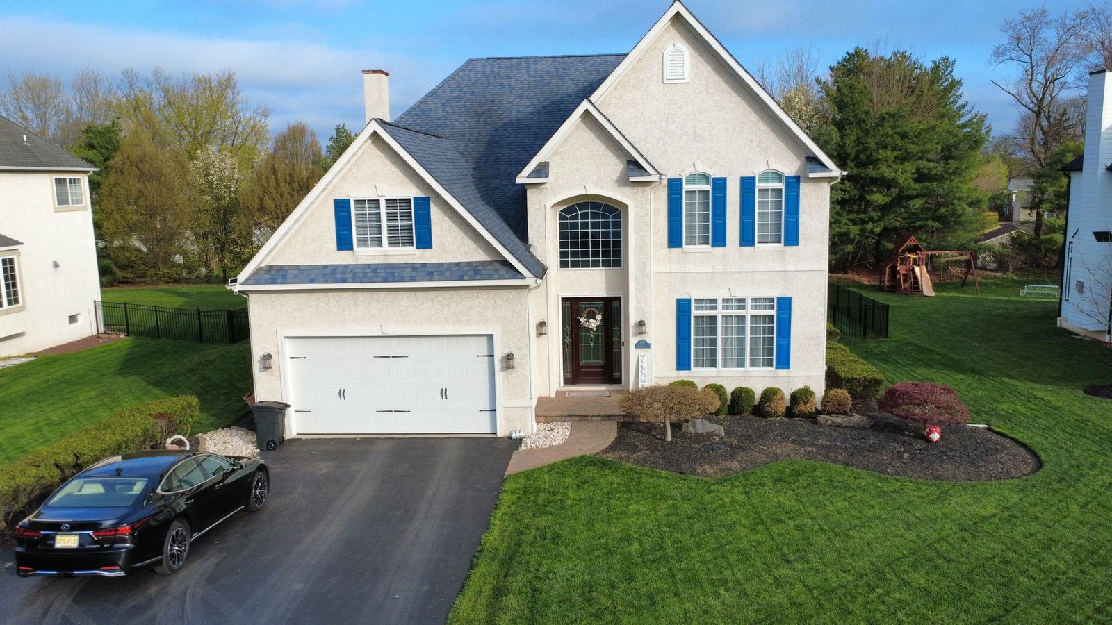 Before — front facade of stucco home with old dark shingles, PA