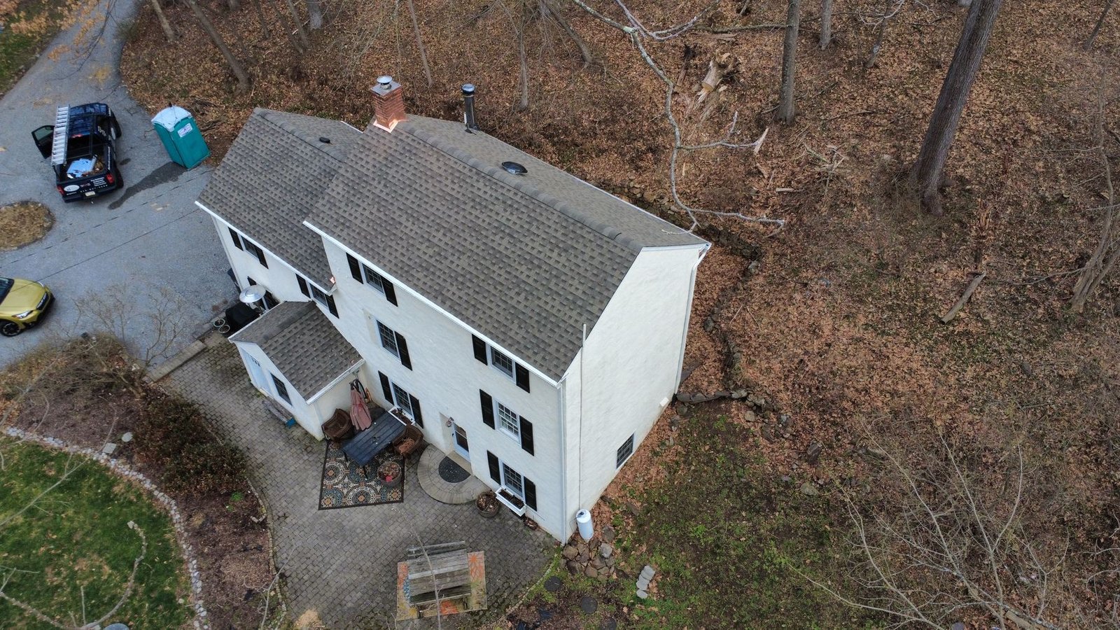 After — front aerial of white cottage with new clean shingles — Shelby Roofing Services PA