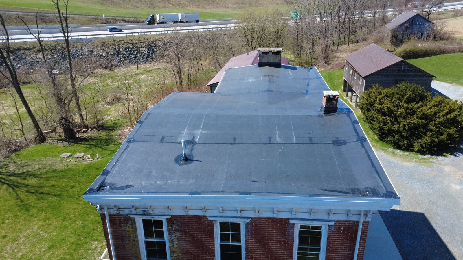 After — side aerial of historic brick building with new EPDM roof — Shelby Roofing Services PA