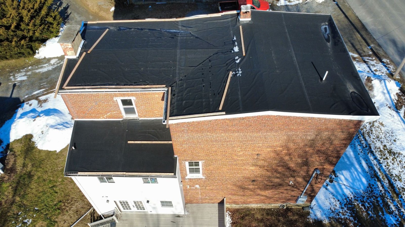 Before — side aerial showing flat roof failure, PA