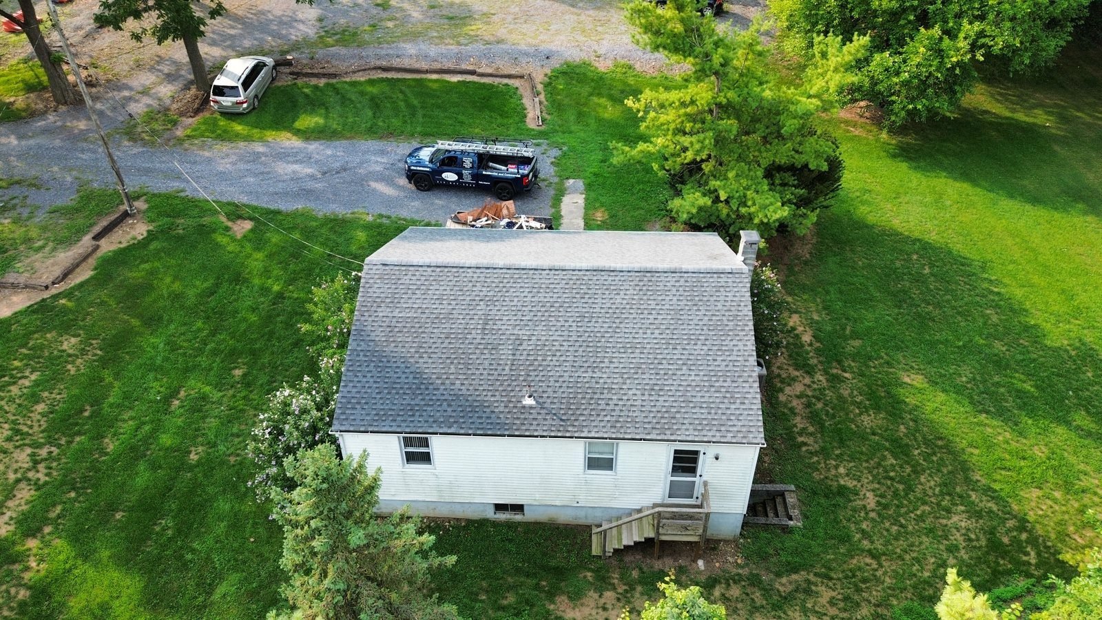 After — aerial view of completed ranch home with new gray architectural shingles and Shelby Roofing Services truck on site, PA