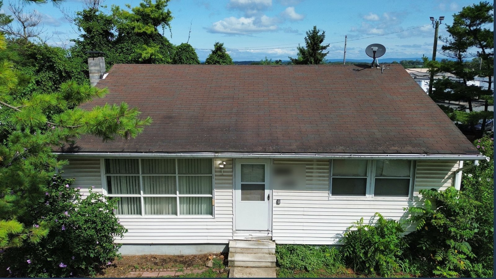 Before — front view of ranch home with worn brown shingle roof, PA
