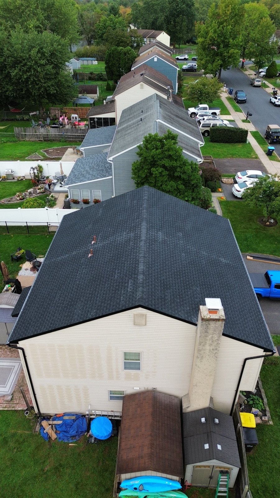 After — chimney side aerial of new black roof with copper chimney flashing — Shelby Roofing Services PA
