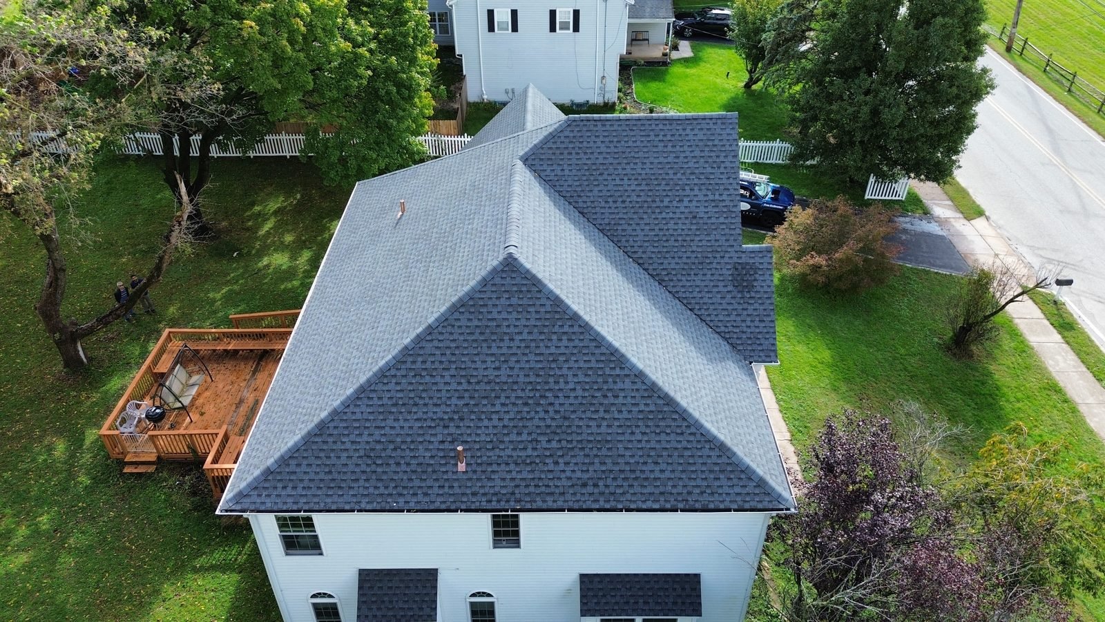 After — rear corner aerial with deck showing the new gray shingle roof and copper pipe flashing, Plymouth Meeting PA — Shelby Roofing Services