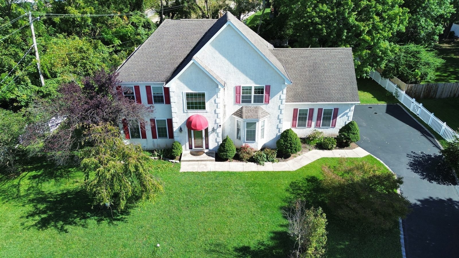 Before — front aerial of stucco colonial with the original brown shingle roof, Plymouth Meeting PA