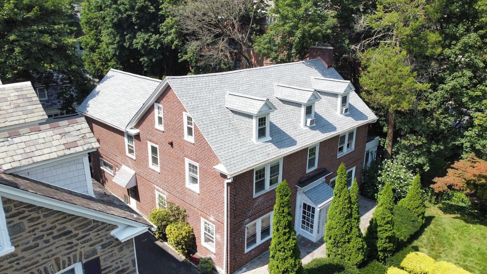 After — front aerial of brick colonial with new light gray architectural shingles — Shelby Roofing Services PA