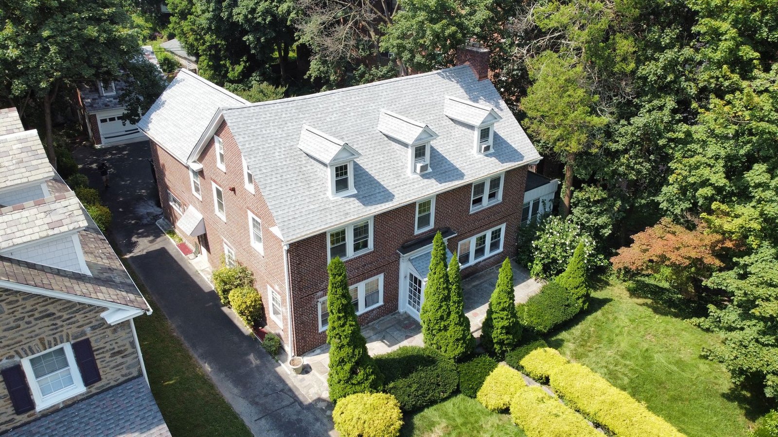 Completed shingle replacement on brick colonial — front aerial view, PA