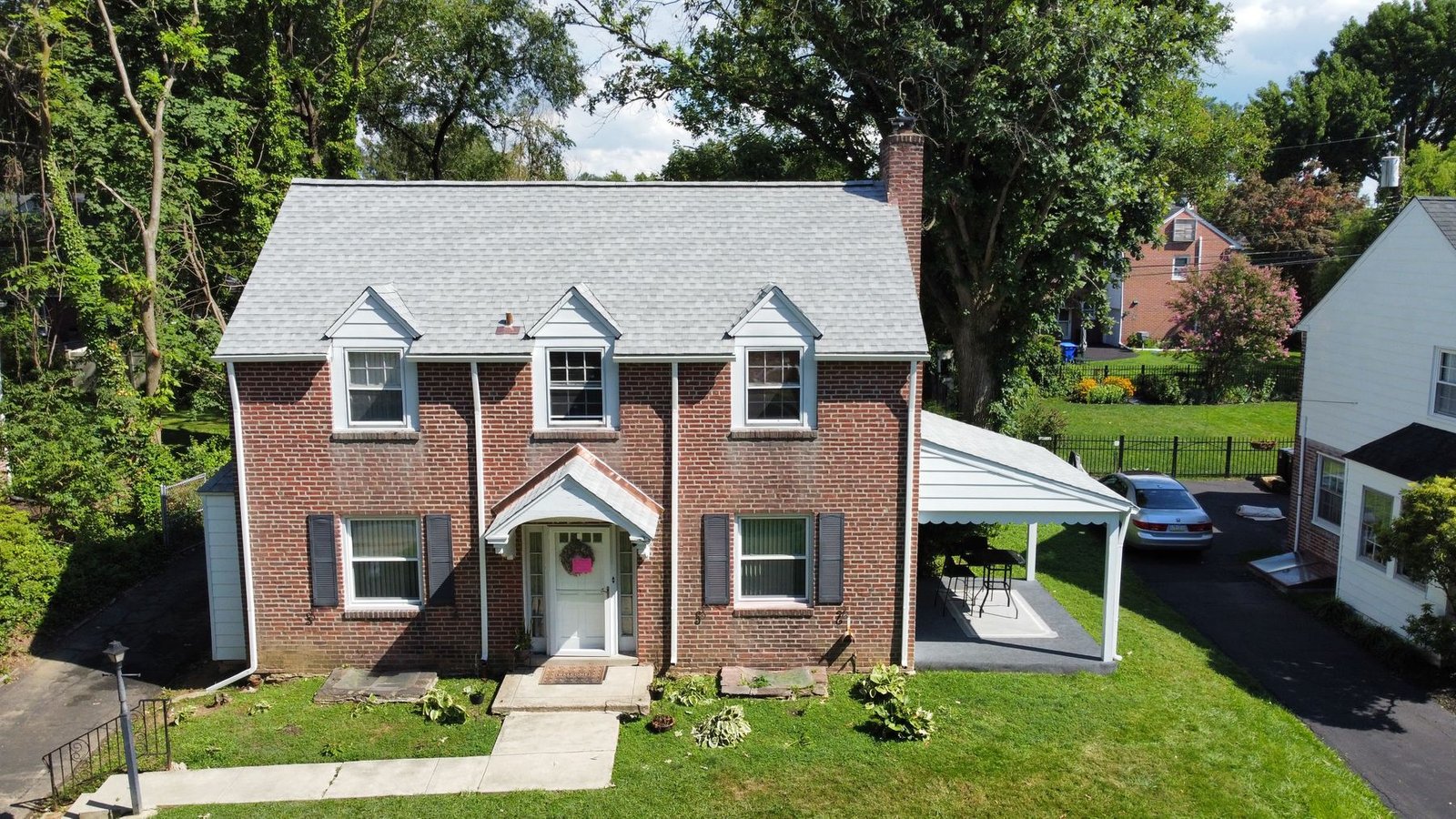 After — front facade of brick colonial showing all new gray dimensional shingles — Shelby Roofing Services PA