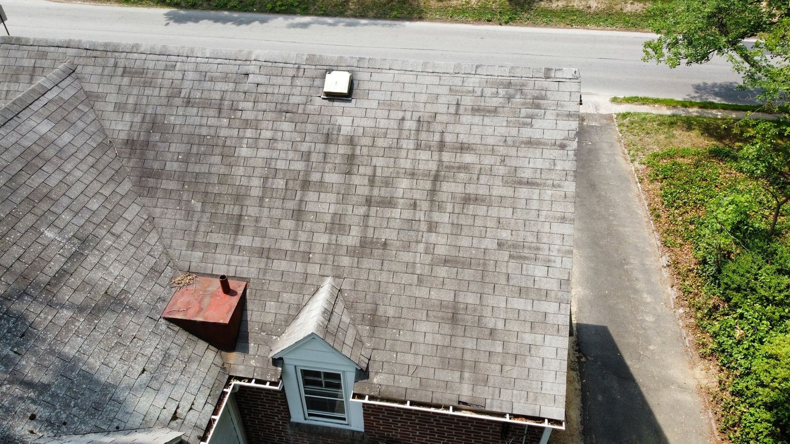 Before — front-right aerial showing chimney and dormer with worn shingles, PA