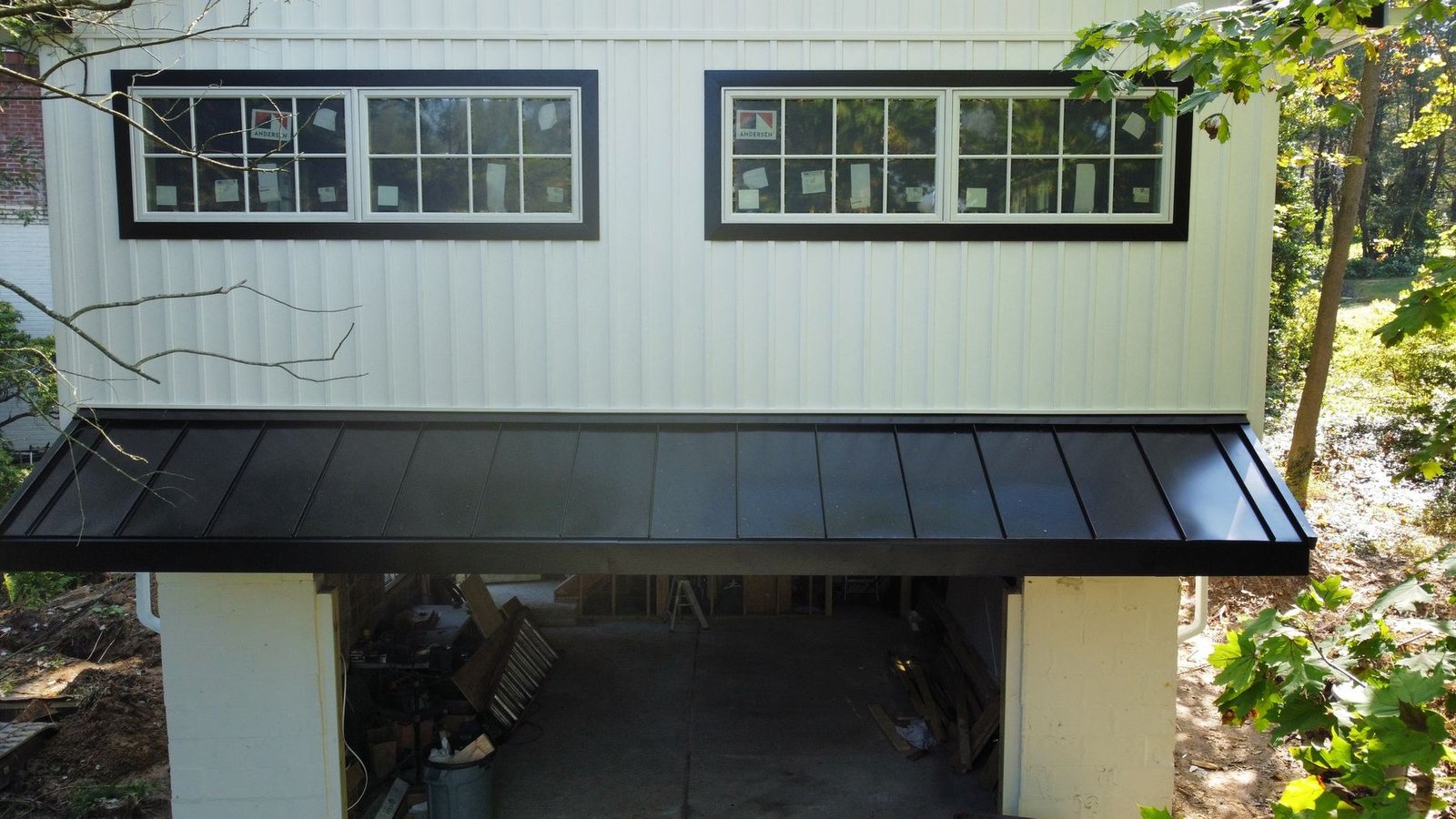 After — new standing seam metal awning with black finish below new siding and windows — Shelby Roofing Services PA