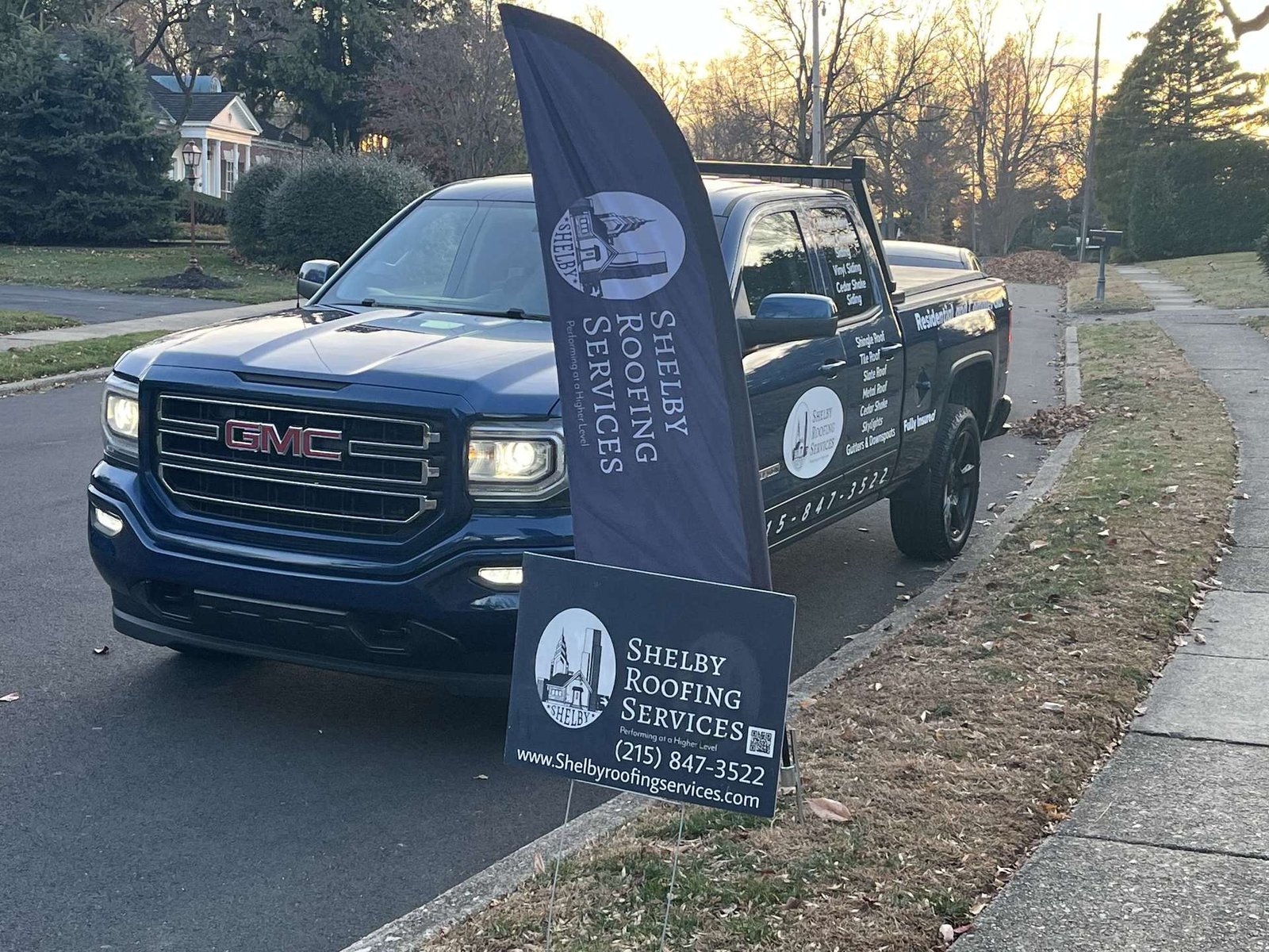 Shelby Roofing Services branded truck and banner at a job site