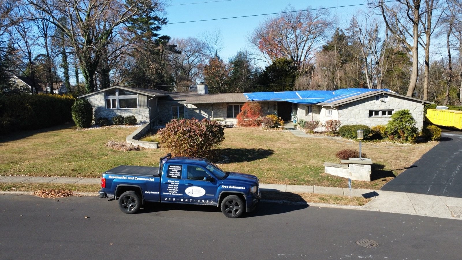 Shelby Roofing Services truck on site for emergency storm response — blue tarp installed on damaged roof